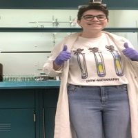 A student smiling while working with lab equipment